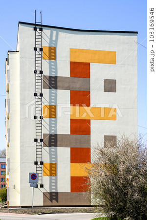 Renovated and insulated multistorey apartment building facade fragment against a blue sky background 103169546