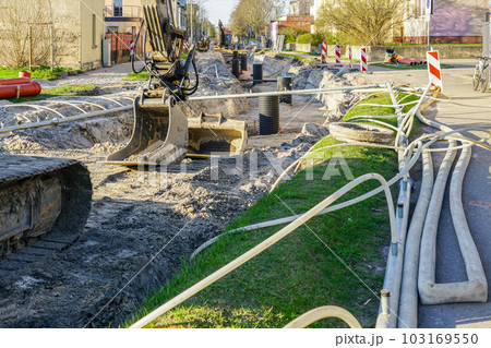 Street reconstruction view with dewatering system hoses and crawler excavators at deep trench Street reconstruction view with dewatering system hoses and crawler excavators at deep trench 103169550