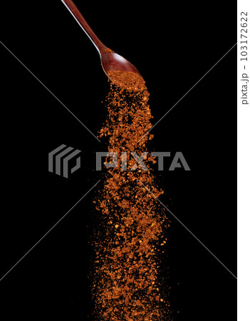 Red Hot Chilli fall, red grain chilli explode abstract cloud fly from wooden spoon. Beautiful complete seed chilly, food object design. Selective focus freeze shot black background isolated 103172622
