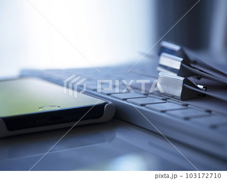 テーブルに置かれた書類とキーボードとスマートフォン テーブルに置かれた書類とキーボードとスマートフォン 103172710