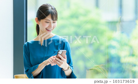 オフィスでスマートフォンを使う女性 オフィスでスマートフォンを使う女性 103173619