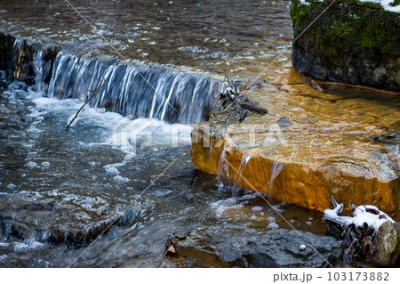 Small waterfalls on the river, limestone layers painted in orange with iron ochre Small waterfalls on the river, limestone layers painted in orange with iron ochre 103173882