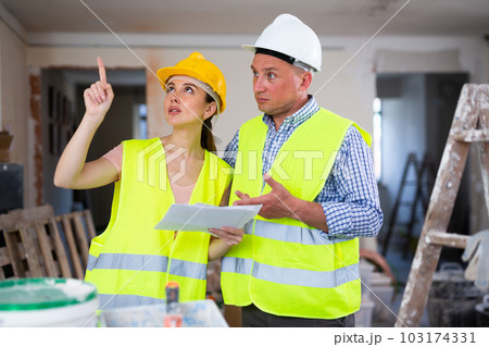 Man and woman builders talking in house 103174331