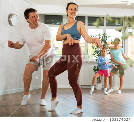 Parents with young daughter and schoolboy son are taught to move to boogie-woogie Parents with young daughter and schoolboy son are taught to move to boogie-woogie 103174624