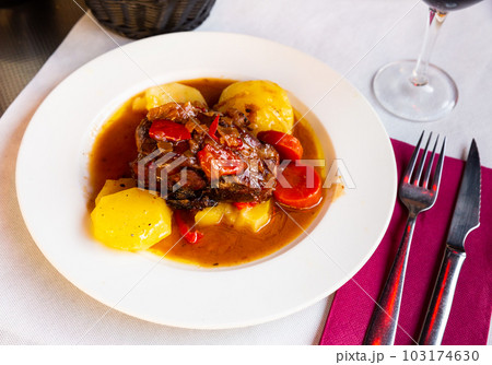 Pork knuckle with potatoes and stewed bell peppers closeup Pork knuckle with potatoes and stewed bell peppers closeup 103174630