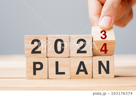 hand flipping block 2023 to 2024 PLAN text on table. Resolution, strategy, goal, motivation, reboot, business and New Year holiday concepts 103176374