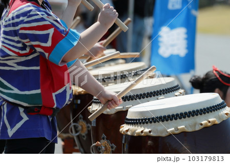 お祭りで大太鼓を叩く女性達 103179813