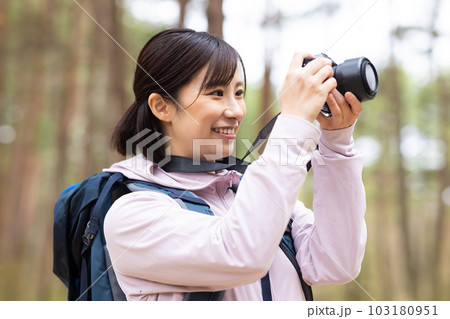 カメラを構えるハイキンをするグ女性 103180951