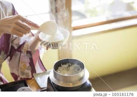旅館朝食イメージ お釜で炊いた炊き立てご飯をよそる女性手元 旅館朝食イメージ お釜で炊いた炊き立てご飯をよそる女性手元 103181176