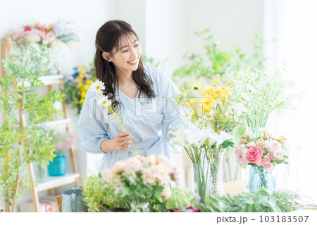 フラワーショップで働く若い女性の店員 フラワーショップで働く若い女性の店員 103183507
