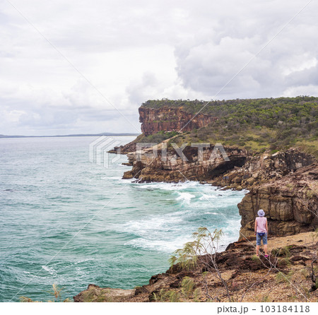 Australia, New South Wales, Port Macquarie, Woman standing on cliff and looking at view Australia, New South Wales, Port Macquarie, Woman standing on cliff and looking at view 103184118