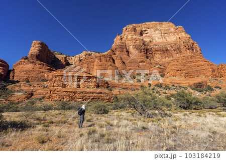 United States, Arizona, Sedona, Senior blonde woman hiking in wilderness 103184219