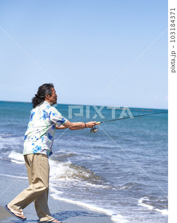 晴れた日の海辺で釣りをする男性 103184371