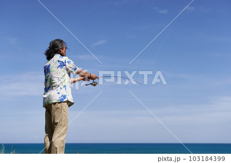 青空のもとで釣りをするミドルシニア男性 103184399