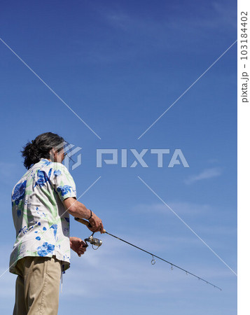 青空のもとで釣りをするミドルシニア男性 103184402