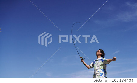 青空のもとで釣りをするミドルシニア男性 103184404