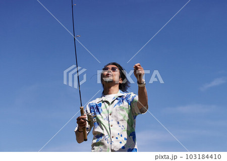 青空のもとで釣りをするミドルシニア男性 103184410