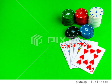 Poker chips in stacks and royal flush on the poker table. Poker chips in stacks and royal flush on the poker table. 103186336