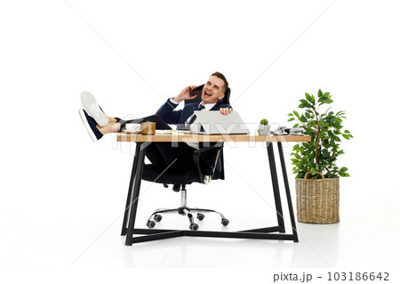 businessman working with laptop and having phone conversation with client 103186642