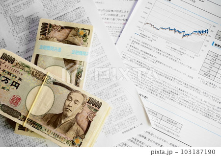 資料の上に積み上げられた一万円札 資料の上に積み上げられた一万円札 103187190