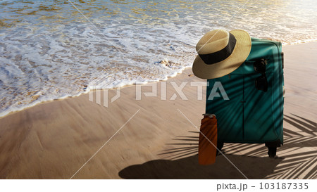 Hat and suitcase on the sandy beach 103187335