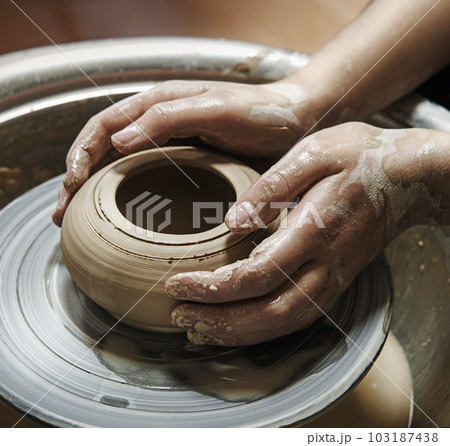 Master's hands mold a jug on a potter's wheel 103187438
