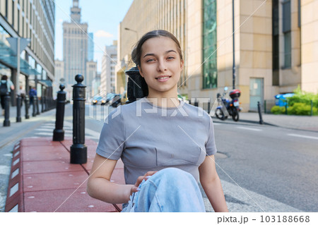 Young smiling teenage girl looking at camera on street of modern city 103188668