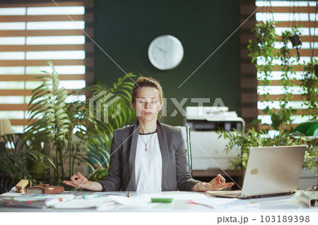 relaxed modern business woman at work with laptop meditating 103189398