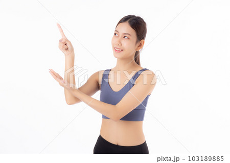 Portrait of beautiful young asian woman in sportwear smile and presenting isolated. 103189885