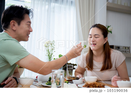 Happiness asian family with husband and wife eating dining food together in the kitchen. Happiness asian family with husband and wife eating dining food together in the kitchen. 103190036