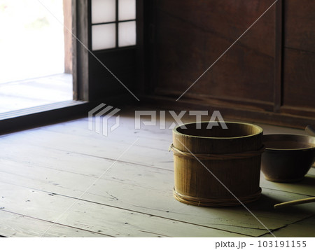 光が射す日本家屋の板の間に木の桶 103191155