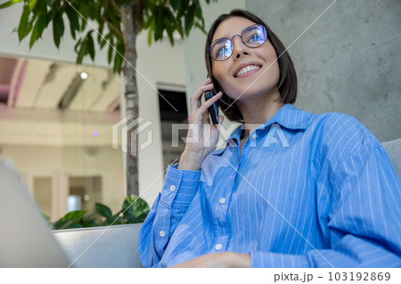 Pleased woman calling on the cellphone indoors Pleased woman calling on the cellphone indoors 103192869