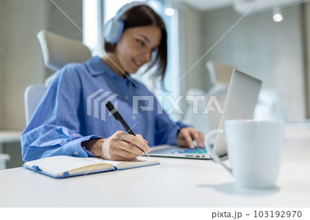 Pleased office worker making notes in her diary Pleased office worker making notes in her diary 103192970