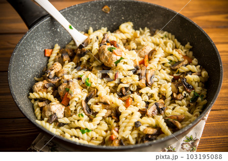vermicelli cooked with mushrooms, meat and vegetables in a frying pan vermicelli cooked with mushrooms, meat and vegetables in a frying pan 103195088