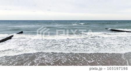 Panoramic beach landscape with shore water and wooden breakwaters 103197198