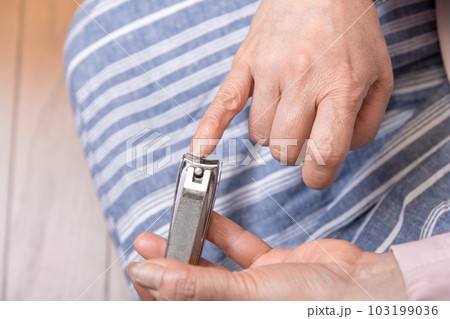 【手の爪を切るミドル女性 フローリング】 【手の爪を切るミドル女性 フローリング】 103199036