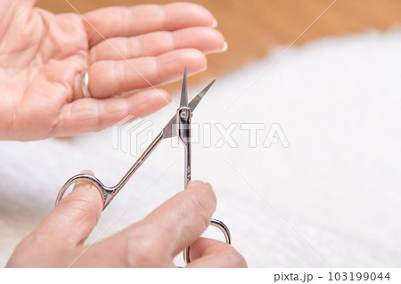 【ハサミで手の爪を切るミドル女性　ムートン】 103199044