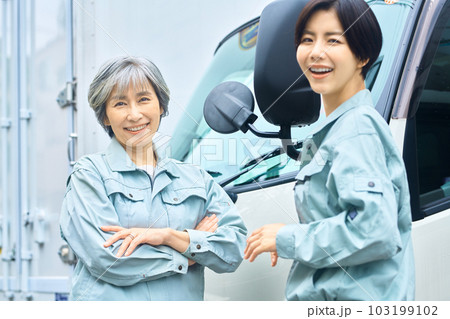 トラックの前で打ち合わせする作業員の女性 トラックの前で打ち合わせする作業員の女性 103199102