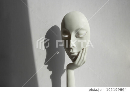 A statuette with the face of a young girl on her arm stands on a white background 103199664