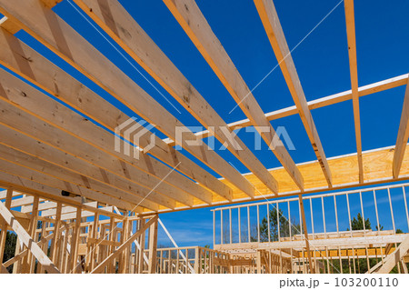 Building wooden house begins with framing beams which support layout of joists. 103200110