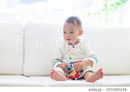 Baby boy playing with toy train Baby boy playing with toy train 103200248