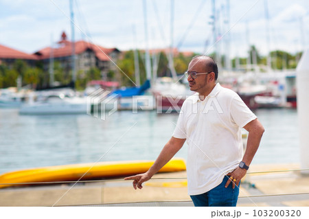 Young man walking in yacht club resort. 103200320
