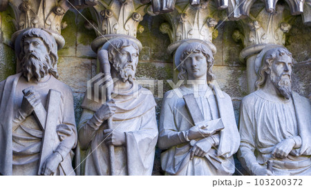 Sculptural images of the Holy Apostles on the wall of Saint Fin Barre's Cathedral in Cork, Ireland. The Apostles Andrew, James major, Thomas, Matthias. Black and white image. Monochrome. 103200372
