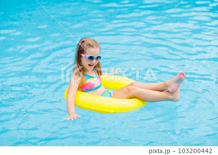 Child in swimming pool on toy ring. Kids swim. 103200442
