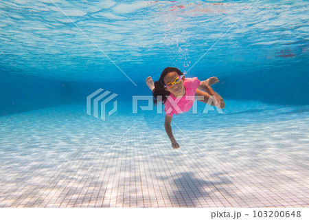 Child in swimming pool on ring toy. Kids swim. 103200648