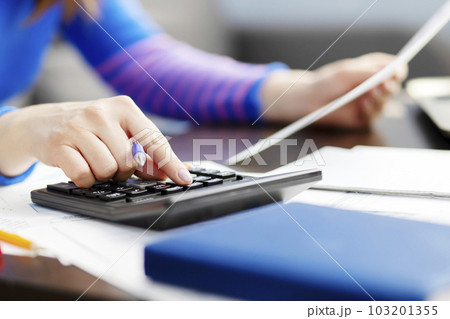 Woman using calculator for calculate domestic bills at home, doing paperwork 103201355
