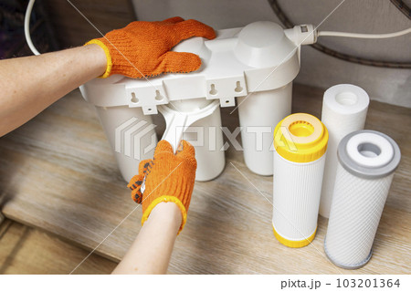 Plumber installs or change water filter. Replacement aqua filter Plumber installs or change water filter. Replacement aqua filter 103201364
