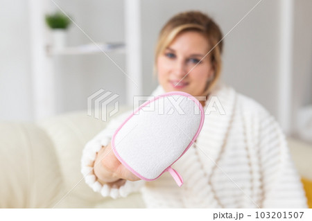 Woman hand holding massage sponge - spa and body care concept Woman hand holding massage sponge - spa and body care concept 103201507