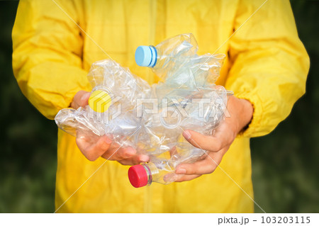 Volunteer hands holding bottle plastic garbage. Environment clean up park cleaning trash nature. Volunteer cleaning forest. PET waste plastic hand trash pick up garbage nature. PET plastic pollution Volunteer hands holding bottle plastic garbage. Environment clean up park cleaning trash nature. Volunteer cleaning forest. PET waste plastic hand trash pick up garbage nature. PET plastic pollution 103203115