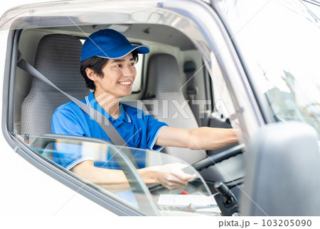 トラックを運転する若い男性ドライバー 103205090
